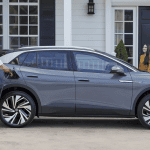 couple charging volks wagon electric vehicle infront of house